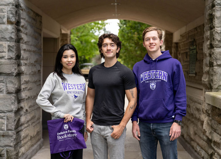 Western students holding Dellelce Family Bookstore shopping bag